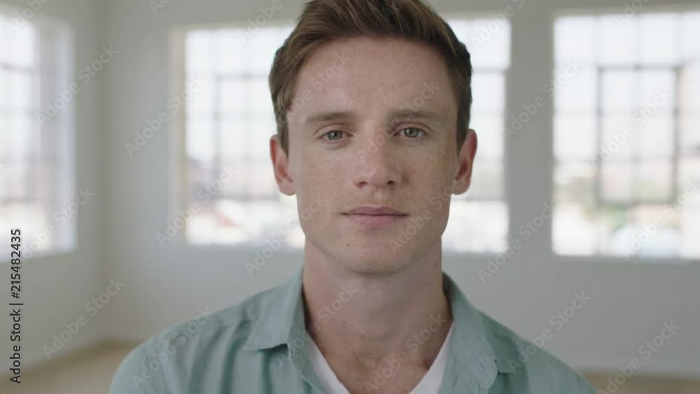 young attractive man portrait of red head guy looking confident pensive at camera in apartment windows background young attractive man portrait of red head guy looking confident pensive at camera in apartment windows background