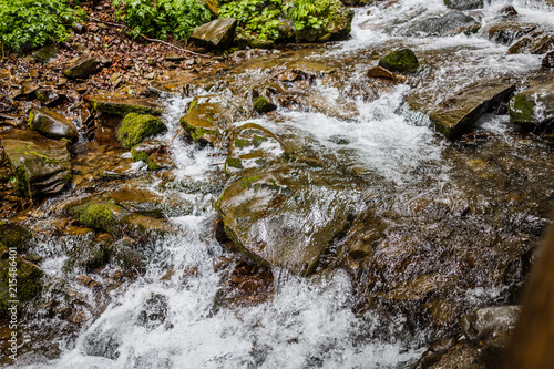 River Water Flowing Through Moss Covered Rocks photo