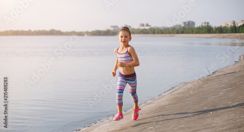 young sporty girl on her morning workout near river photo