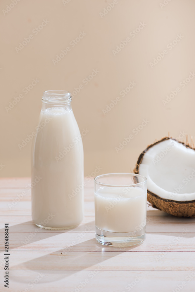 Coconut milk in bottle and glass on table with copy space Coconut milk in bottle and glass on table with copy space