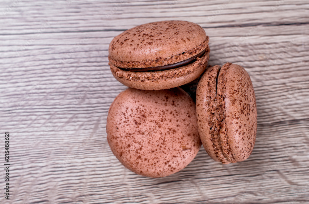 Delicious chocolate french macaroons or macaron on a wooden background whith place for insert text. Copy space Delicious chocolate french macaroons or macaron on a wooden background whith place for insert text. Copy space