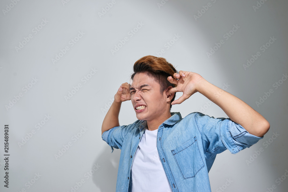 displeased man plugging ears with fingers doesn't want to listen isolated on gray wall background displeased man plugging ears with fingers doesn't want to listen isolated on gray wall background