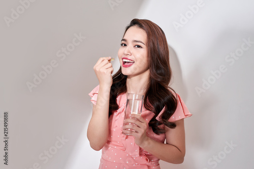 beautiful asian women eating vitamin pill for health care at home