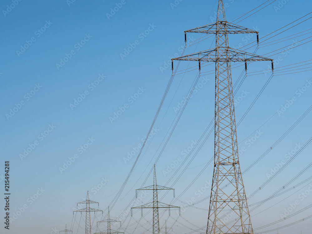Electricity Pylons and Lines against blue sky background.