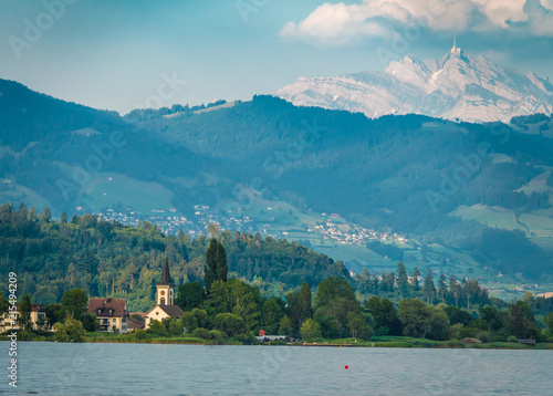 View of the Upper Zrucih Lake (Obersee), with the Santis peak and the village of Busskirch in the background, Sankt Gallen, Switzerland photo