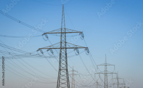 Electricity Pylons and Lines against blue sky background.