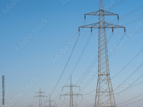 Electricity Pylons and Lines against blue sky background.