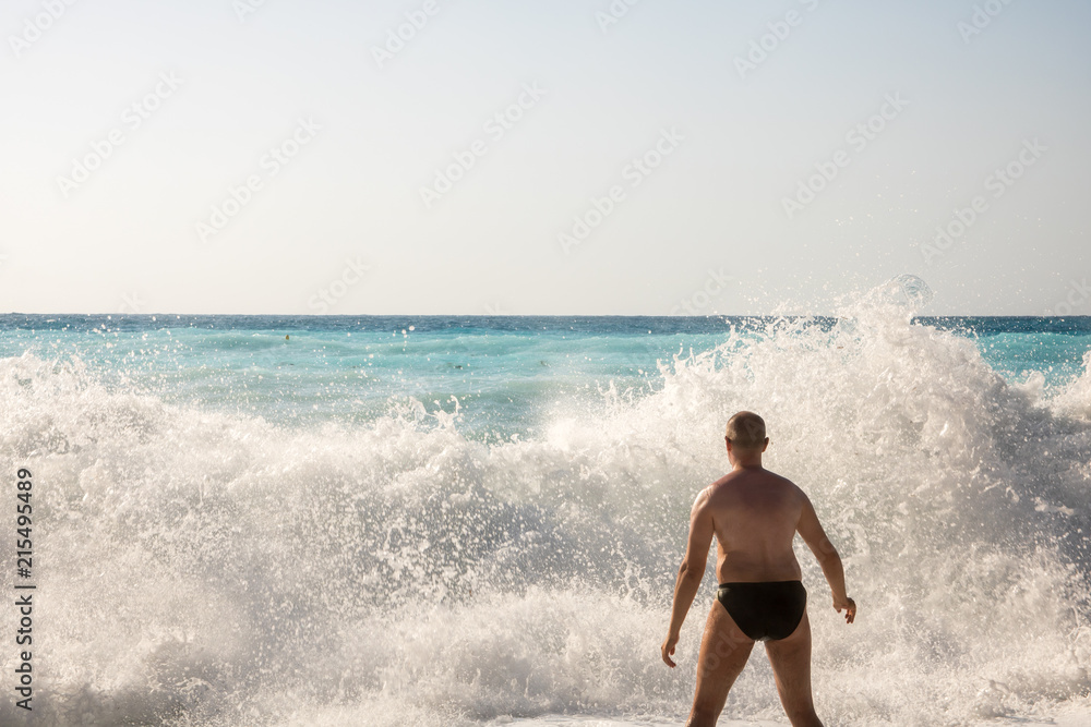 Man chasing the waves on Myrtos beach, island Kefalonia, Greece Man chasing the waves on Myrtos beach, island Kefalonia, Greece