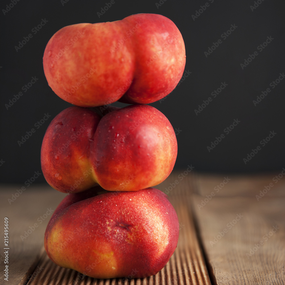 Peaches and Nectarines fruits. Concept for healthy nutrition. Dark black background and wooden table. Isolated. Square iamge. Peaches and Nectarines fruits. Concept for healthy nutrition. Dark black background and wooden table. Isolated. Square iamge.