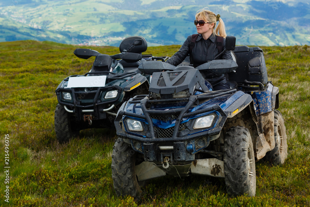 Excited young woman on quad bike. Happy young woman driving all terrain vehicle in nature. Excited young woman on quad bike. Happy young woman driving all terrain vehicle in nature.