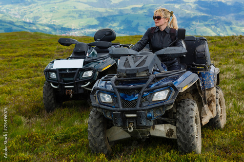 Excited young woman on quad bike. Happy young woman driving all terrain vehicle in nature.