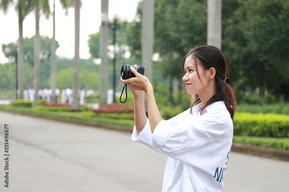 a woman taking photos in a park in Vietnam