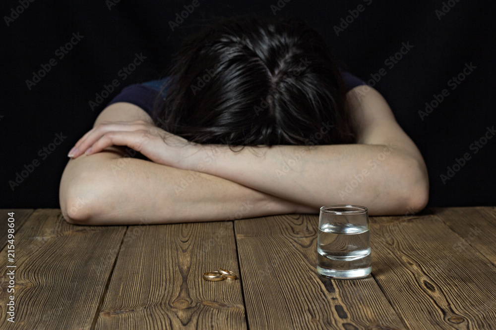 A drunk girl lies on a wooden table, laid her head on a table, a black  background, female alcoholism Stock Photo | Adobe Stock