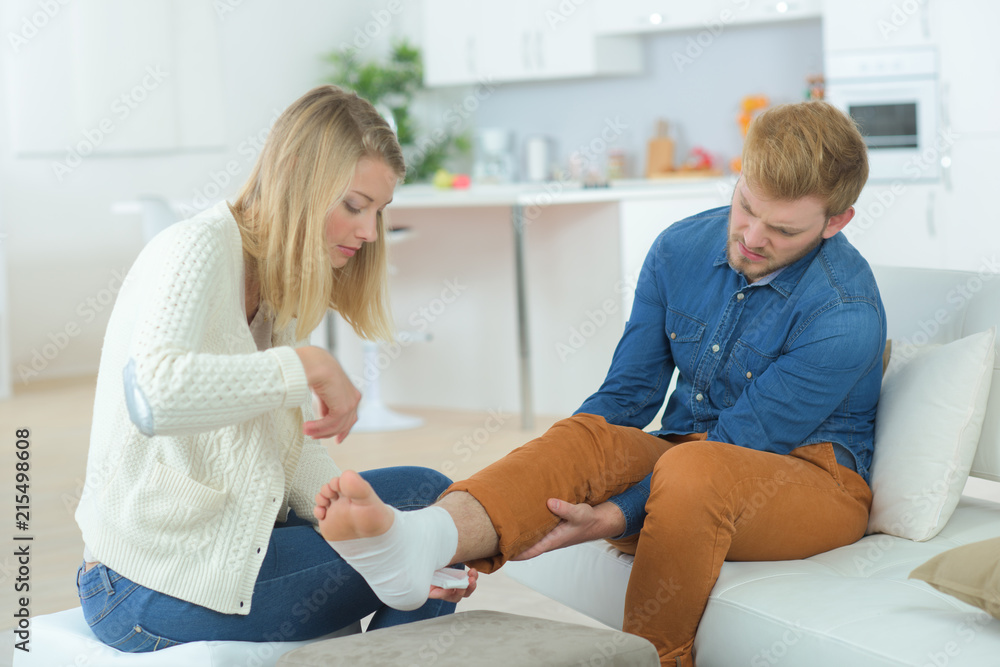 Fototapeta premium Helping boyfriend with damaged ankle