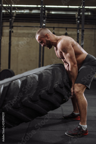 angru shirtless bodybuilder can't flip the tire. side view photo photo