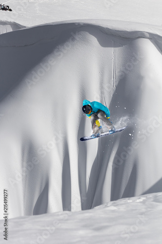 Flying snowboarder on mountains. Extreme winter sport.