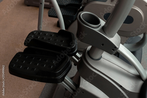 modern new grey and black step machine standing in the gym with pedals close up. concept of sports equipment