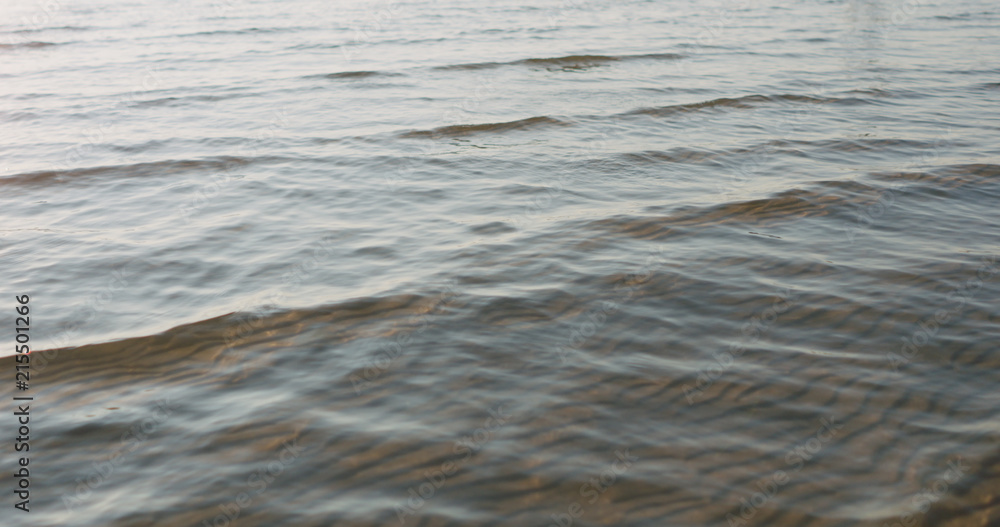 small waves on sandy sea beach on a sunny day small waves on sandy sea beach on a sunny day