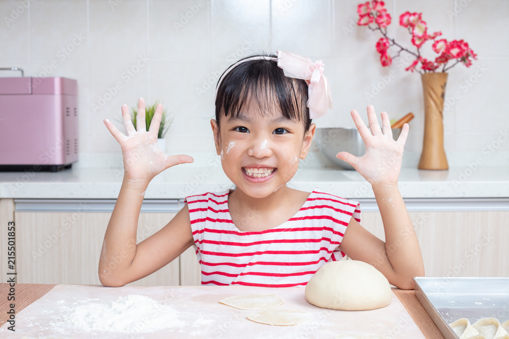 Asian Chinese little girl making dumpling in the kitchen Asian Chinese little girl making dumpling in the kitchen