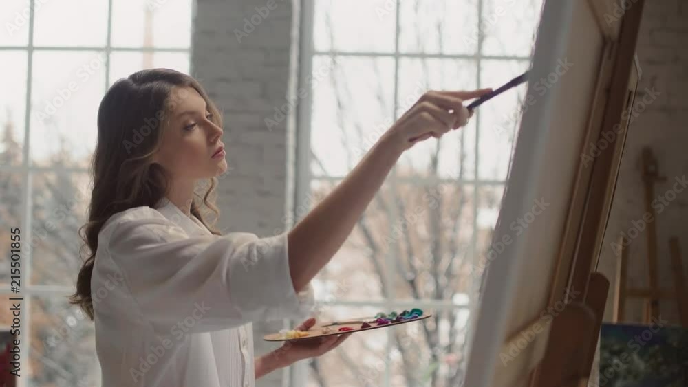 Beautiful girl paints on a canvas, the average plan, oil on canvas. Beautiful girl paints on a canvas, the average plan, oil on canvas.