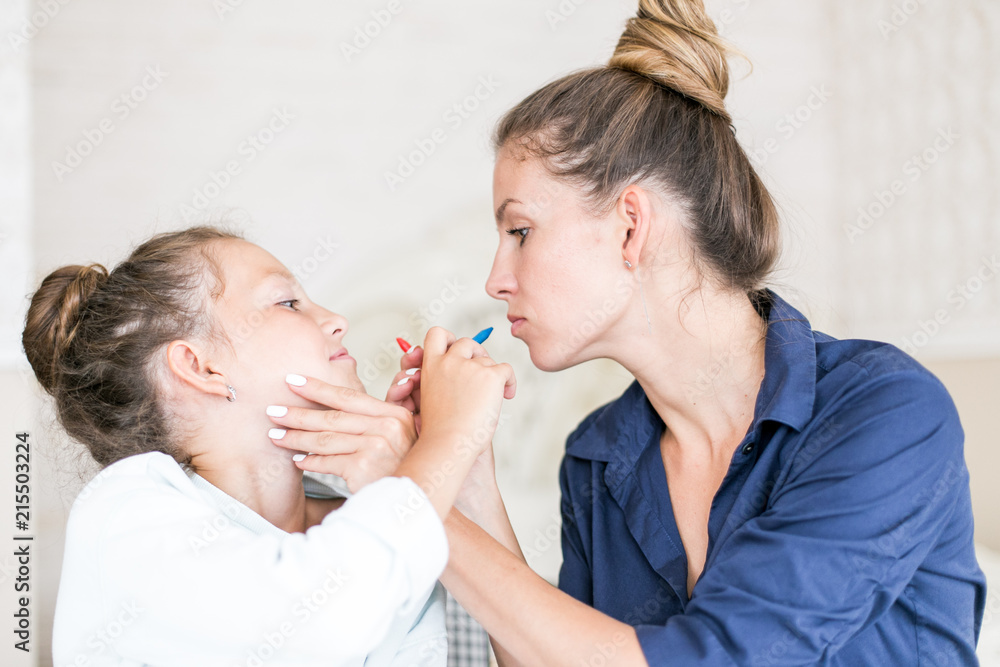 Happy family. Mother and daughter together paint and draw. Adult woman helps the child girl Happy family. Mother and daughter together paint and draw. Adult woman helps the child girl