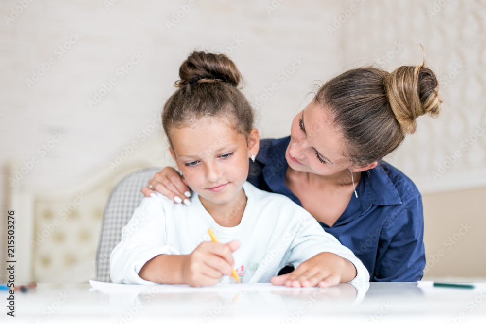 Happy family. Mother and daughter together paint and draw. Adult woman helps the child girl Happy family. Mother and daughter together paint and draw. Adult woman helps the child girl
