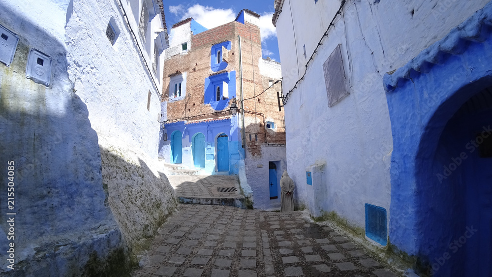 Unidentified man walking in blue medina of Chefchaouen city in Morocco, North Africa Unidentified man walking in blue medina of Chefchaouen city in Morocco, North Africa