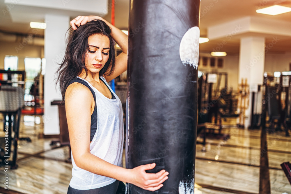 Sporty girl near punching bag in the gym