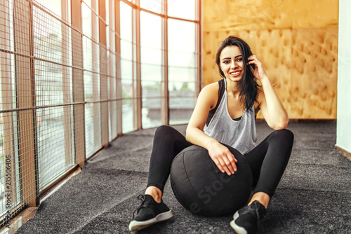 Cute sporty girl sitting in the gym