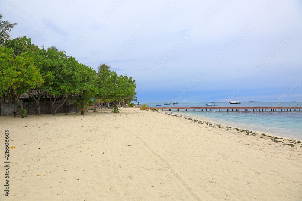 Gorgeous view of on coastline. Indian Ocean, Maldives. Some boats on blue water and blue sky with white clouds background. Amazing nature landscape background. Gorgeous view of on coastline. Indian Ocean, Maldives. Some boats on blue water and blue sky with white clouds background. Amazing nature landscape background.