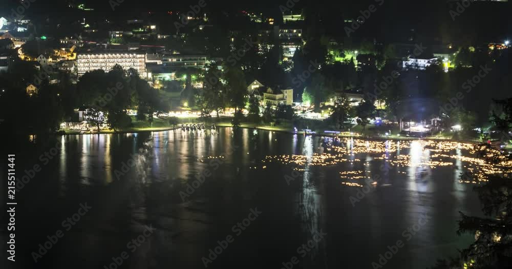 Summer night time lapse of lake Bled annual candle festival. Reflections from the light on the shore make for interesting view while egg shells filled with candles float with the current. Summer night time lapse of lake Bled annual candle festival. Reflections from the light on the shore make for interesting view while egg shells filled with candles float with the current.