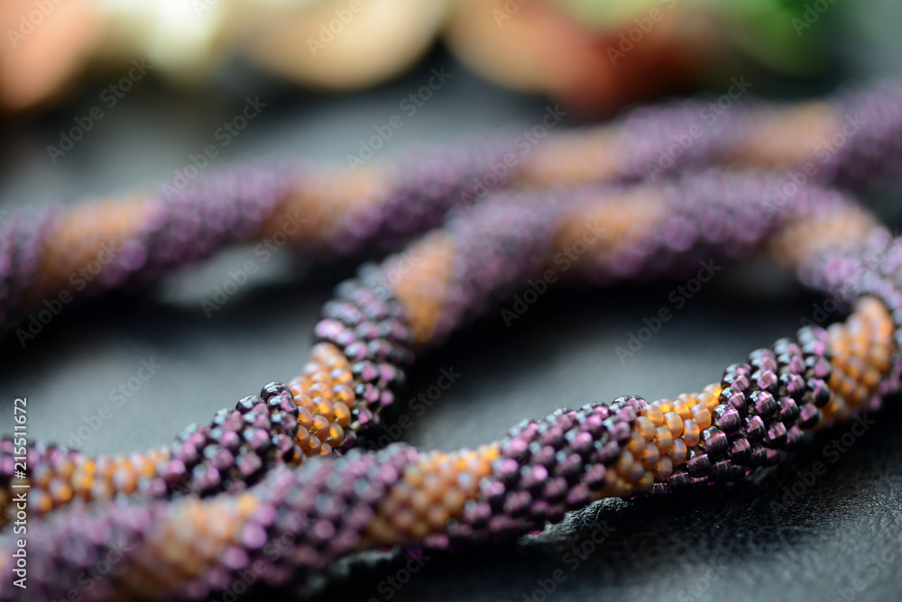 Spiral beaded necklace two colors on a dark background close up Spiral beaded necklace two colors on a dark background close up