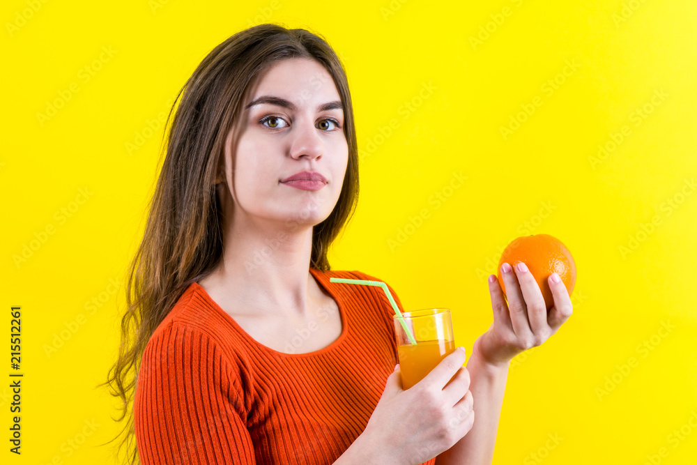 Beautiful happy girl with yellow orange and orange juice on yellow background