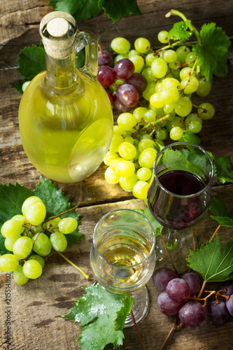 Wine background. White and red wine in glasses, bottle, grapes on vintage background, wine concept.