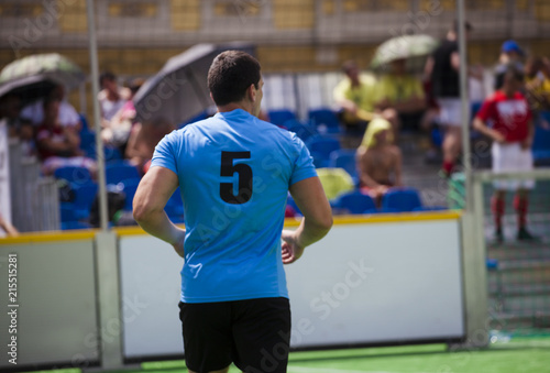 Football player on the football field with a blue T-shirt. Player number five. Soccer game