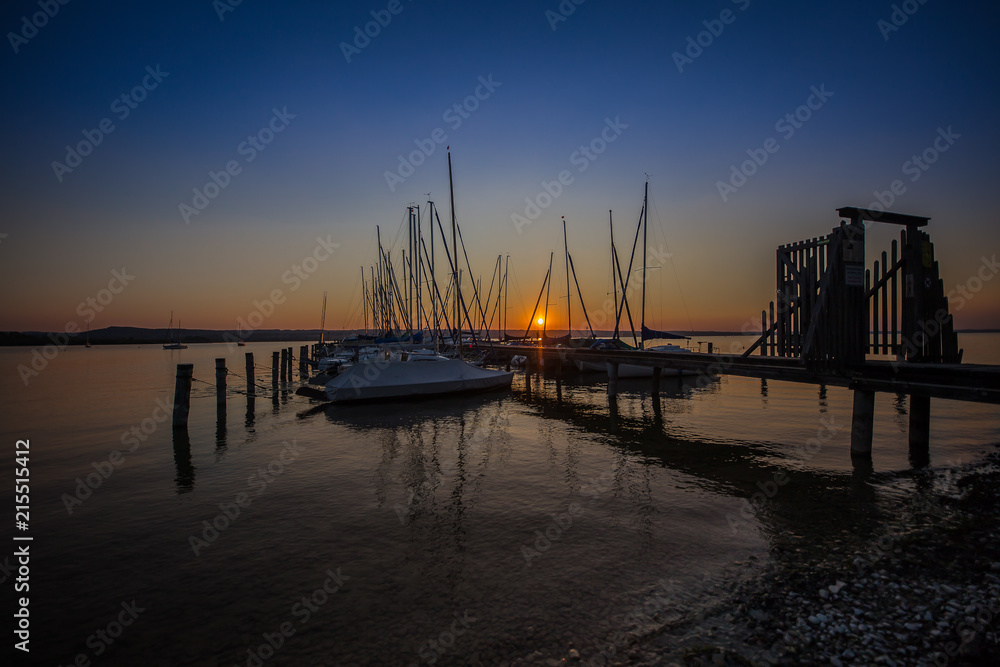 Segelboote mit Bootssteg am Ammersee in der Abendsonne Segelboote mit Bootssteg am Ammersee in der Abendsonne