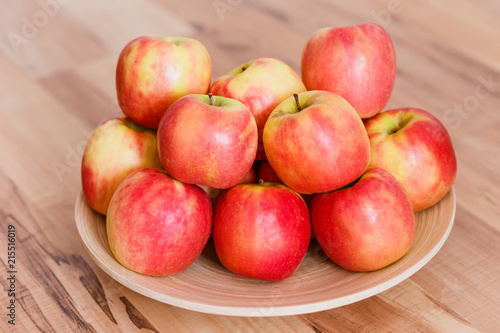 red-yellow ripe apples on a wooden plate