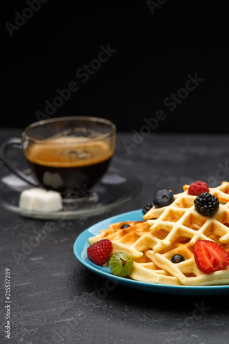 Photo of cup of coffee with Belgian wafers with strawberries, raspberries