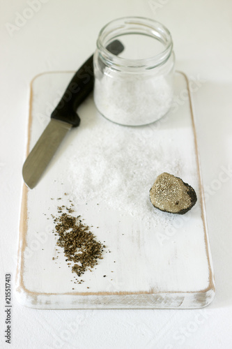 Ingredients for preparation of truffle salt, truffle and salt on a white background. Rustic style.