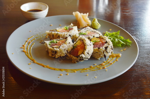 sushi roll stuffed tuna and pickled cucumber slice on plate