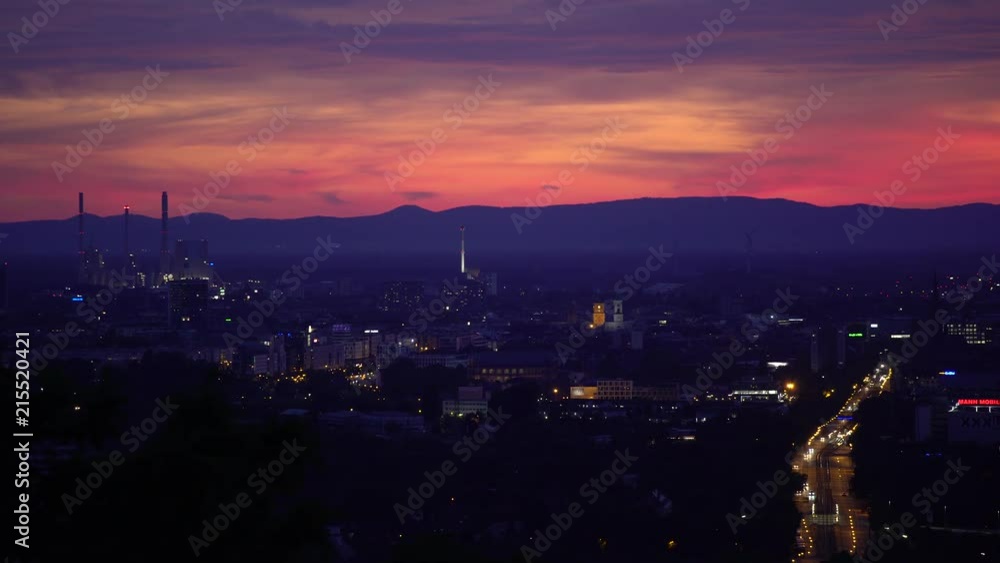city view at night with colourful sky and distant mountain range city view at night with colourful sky and distant mountain range
