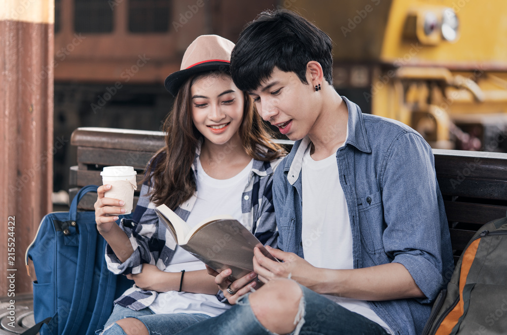 Traveller are reading and have a cup of coffee while waiting their friends Traveller are reading and have a cup of coffee while waiting their friends