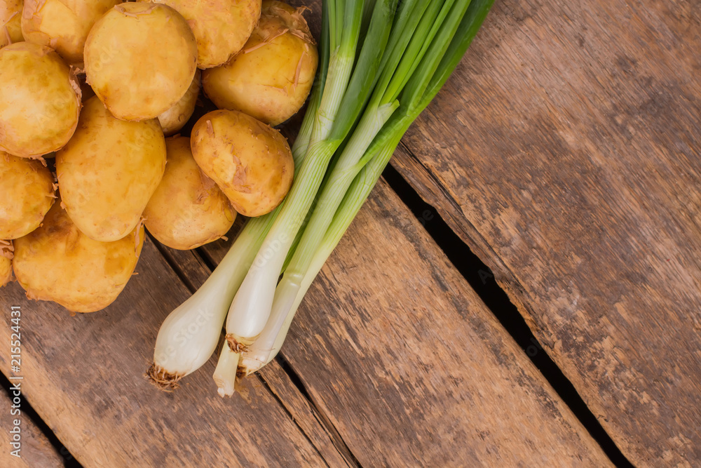 Potatoes and green onions harvest. Top view. Rustic wood background. Potatoes and green onions harvest. Top view. Rustic wood background.