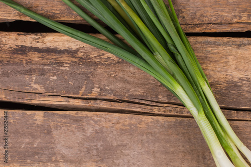 Fresh green onion close up. Old rustic wood background. Top view  free space for your text.
