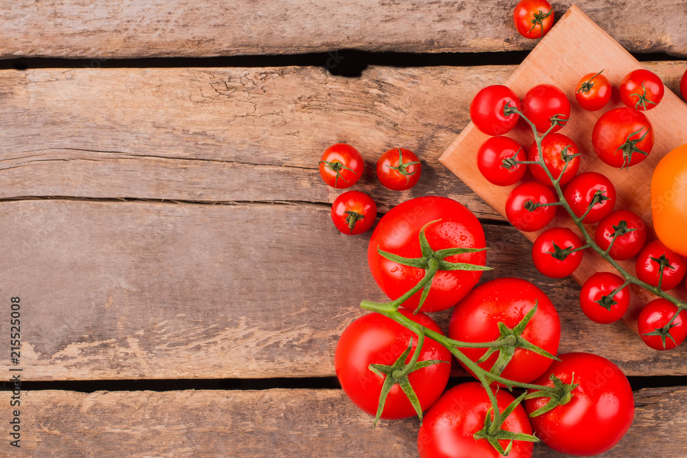 Cherry tomatoes with drops on branch. Old rustic wooden background and copyspace. Cherry tomatoes with drops on branch. Old rustic wooden background and copyspace.
