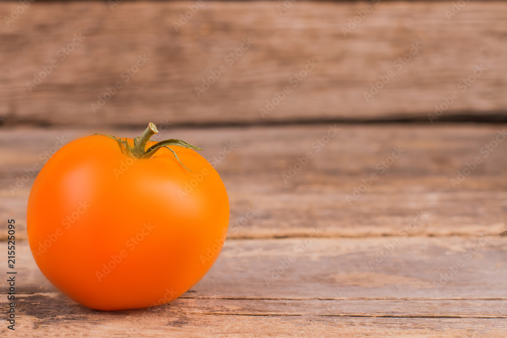 Yellow tomato on wood and copyspace. Close up. Old wooden table. Yellow tomato on wood and copyspace. Close up. Old wooden table.