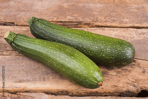 Ripe green zucchini on wood. Old vintage rustic wooden table.