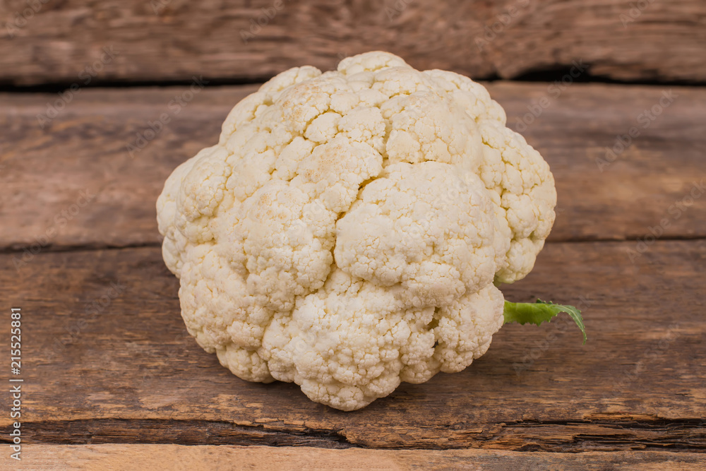 White cauliflower close up. Old rustic wooden table background. White cauliflower close up. Old rustic wooden table background.