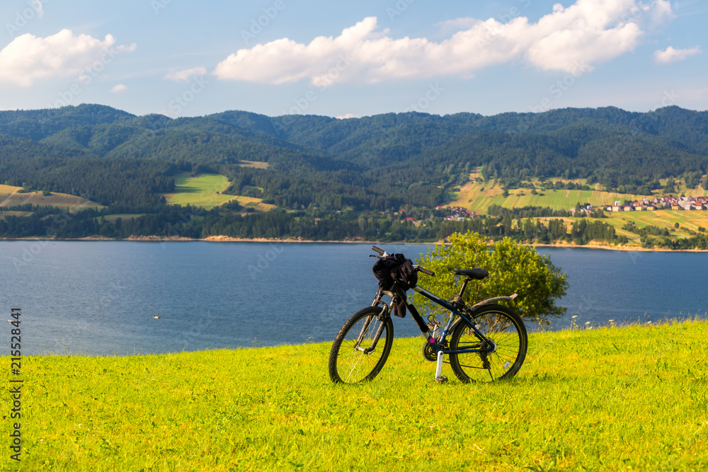 Bike on green grass with a lake