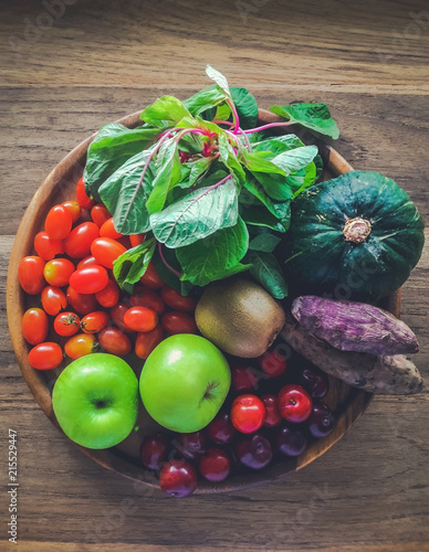 Mix fresh vegetables and fruits in a wood tray on the table, green apple, tomatoes, pumpkin, potatoes and spinach  photo